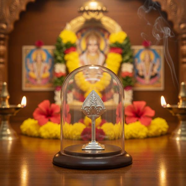 Silver Vel under a dome display with religious artwork and flowers in the background