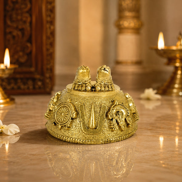 Brass Perumal Patham with shankha and chakra placed on marble floor near diya