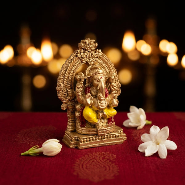 Detailed close-up of the Lord Vinayagar fiber statue with traditional South Indian Prabhavali arch, styled with white jasmine flowers for home pooja decor.