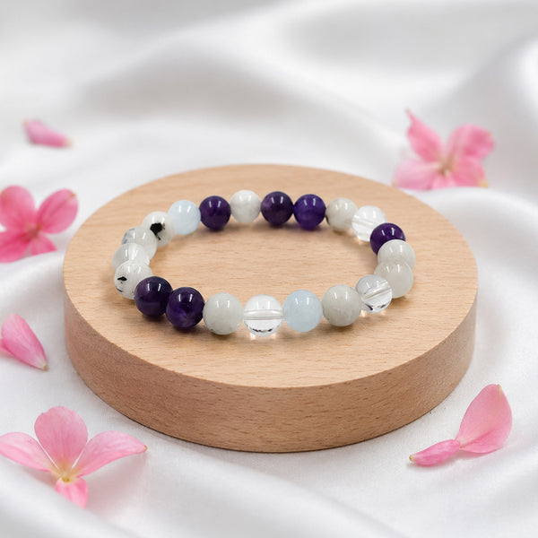 Angled view of the Chandrashtama healing crystal bracelet showing the natural 8mm gemstone beads resting on golden silk.
