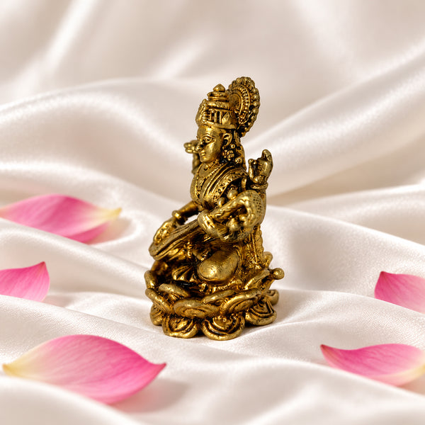 Brass Saraswati idol from an angle showing the crown, jewellery and lotus seat