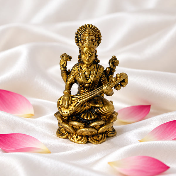 Brass Saraswati idol front view on white silk with lotus petals