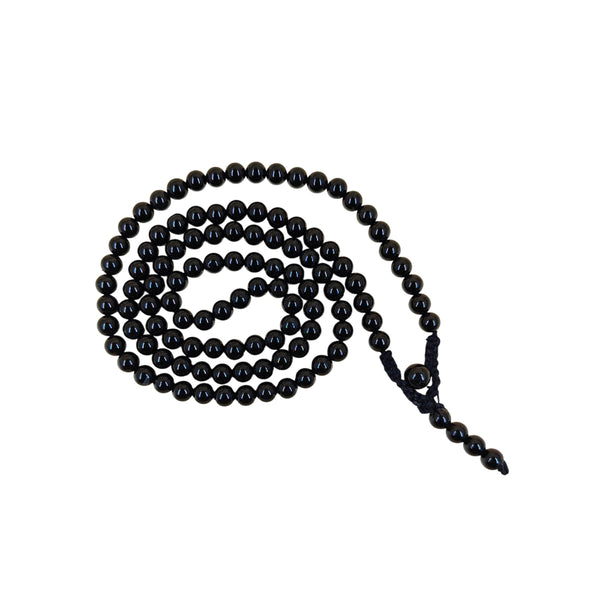 A traditional Black Tourmaline prayer mala coiled in a spiral on a white background, showcasing the smooth, solid black surface of the protective crystal beads.