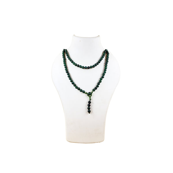  A traditional green jade prayer mala coiled in a spiral on a white background, featuring polished forest-green round beads.