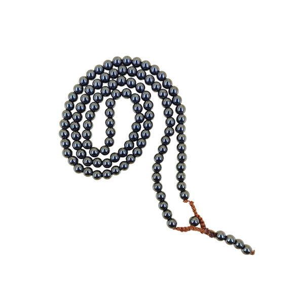 A traditional Hematite crystal mala coiled in a spiral on a white background, showcasing the uniform shiny dark grey beads