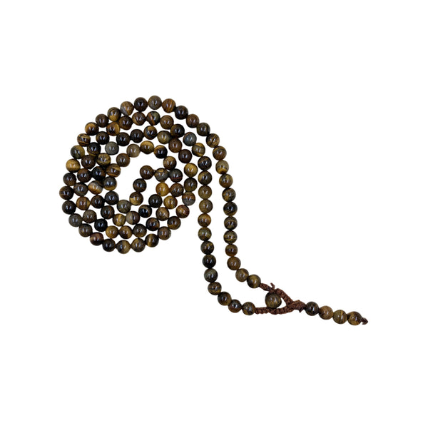 A coiled strand of Tiger's Eye crystal prayer beads on a white background, showcasing the natural golden-brown chatoyant bands of the polished stones.