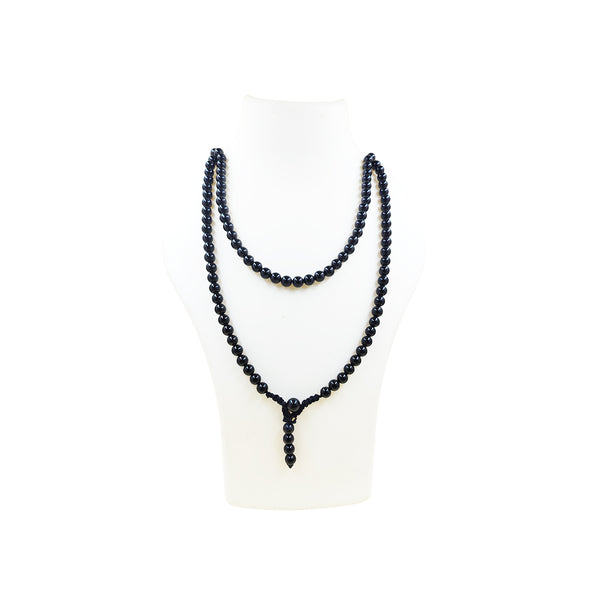 A long Black Tourmaline crystal mala necklace worn doubled over a white jewelry mannequin bust, featuring polished, deep black protective beads.