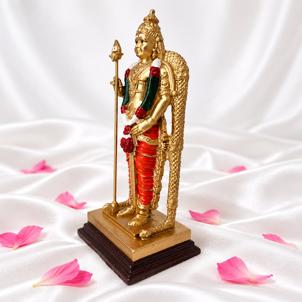 God Murugan statue from an angle showing the vel, garland and patterned arch