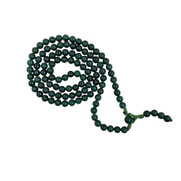 A long strand of polished green jade beads displayed as a mala necklace on a white bust, featuring a matching green cord and decorative tassel beads.