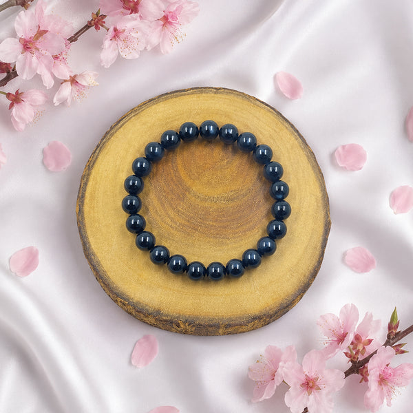 Handcrafted 8mm Black Agate bead bracelet displayed with pink cherry blossoms for a luxury spiritual aesthetic.