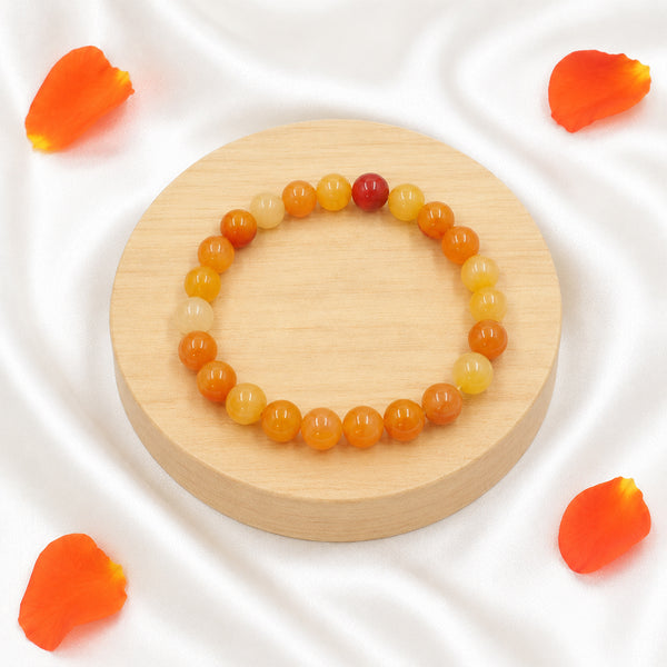 Handcrafted Carnelian stretch bracelet displayed with orange petals for a premium spiritual aesthetic.