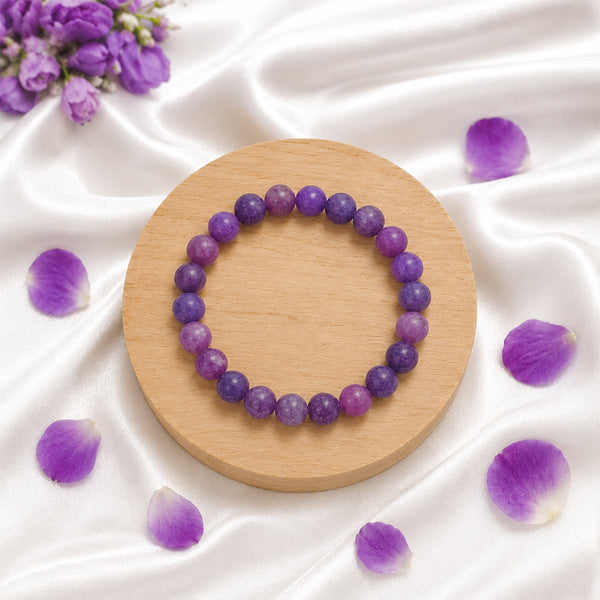 High-quality Lepidolite stretch bracelet displayed with purple flower petals for a luxury spiritual aesthetic.