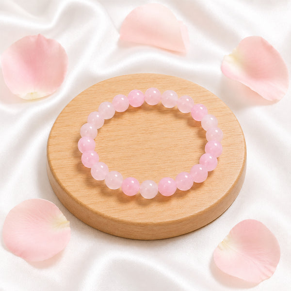 High-quality Rose Quartz stretch bracelet displayed with pink rose petals for a luxury spiritual aesthetic.