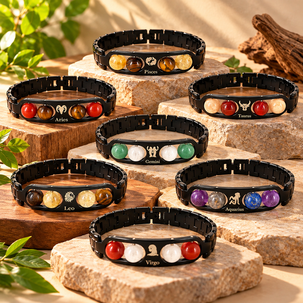 Lifestyle display showing multiple zodiac metal bracelets with black steel links and natural stone bead accents laid out together.