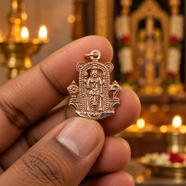 Rose gold Perumal pendant with standing deity under a temple arch, held in hand
