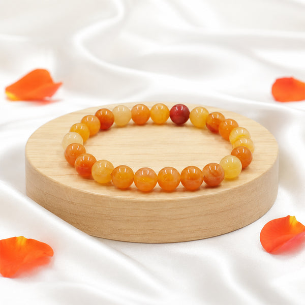 Premium Carnelian crystal bracelet on a wooden display, known as the stone of motivation and creative energy.