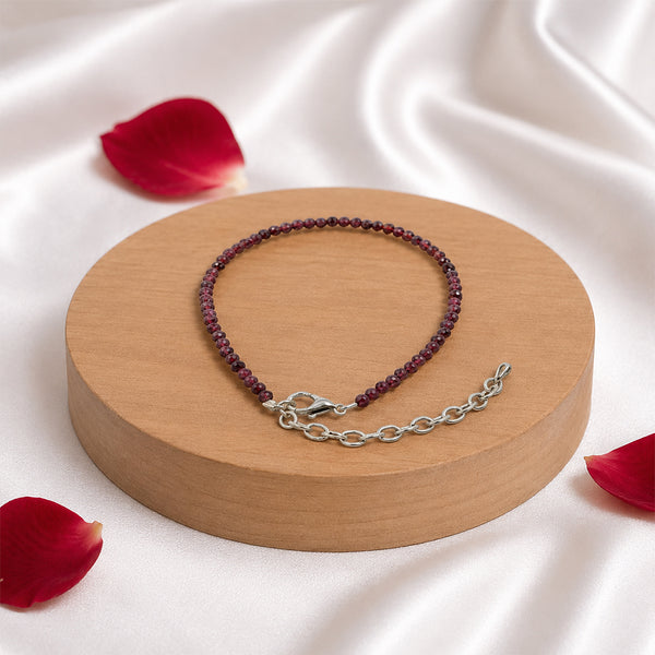 Premium dainty Red Garnet crystal bead bracelet on a wooden display, handcrafted for strength, passion, and commitment.
