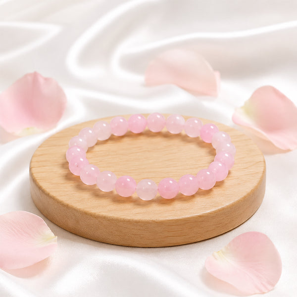 Premium Rose Quartz crystal bracelet on a wooden display, known as the stone of unconditional love and emotional balance.