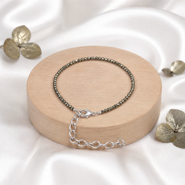 Premium dainty Pyrite crystal bead bracelet on a wooden display, handcrafted for attracting wealth and prosperity.