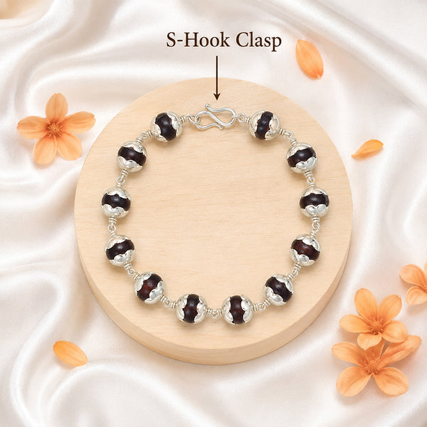 Detailed view of the traditional secure S-hook metal clasp on a silver-capped Red Sandalwood bead bracelet.