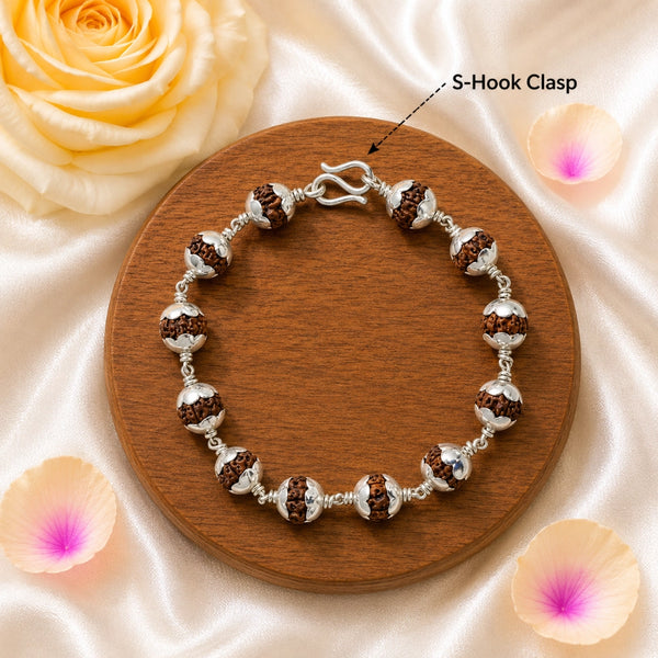 Close-up of the traditional S-hook metal clasp on a silver-capped Rudraksha bead bracelet for extra security.