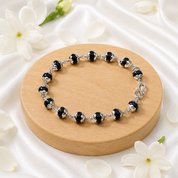 Detailed view of silver-capped Karungali wood beads on a handcrafted wire-wrapped spiritual bracelet.