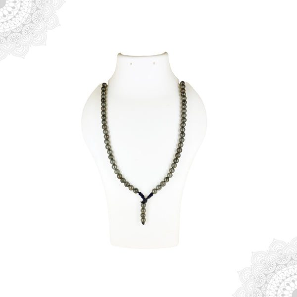 A long Pyrite crystal mala necklace with metallic brassy-grey beads displayed as a single strand on a white mannequin bust.