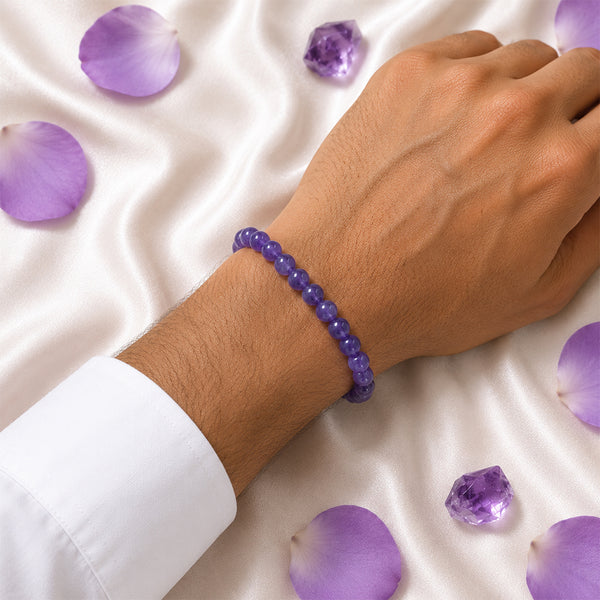 Handcrafted 8mm deep purple Amethyst bead bracelet displayed with loose crystals for a luxury spiritual aesthetic