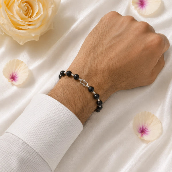 A person wearing the premium Karungali wood bracelet with silver accents, showcasing a stylish and protective spiritual accessory.