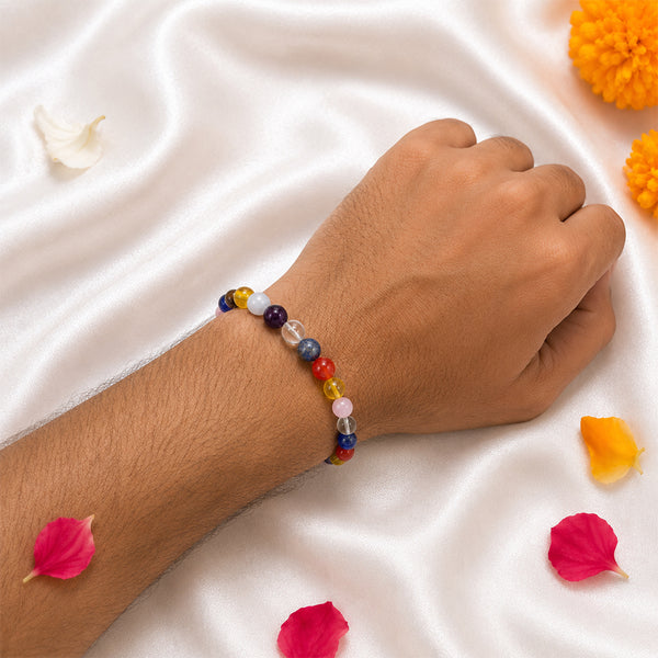A person wearing the multi-color Navratri crystal bracelet on a white silk background for spiritual alignment and festive wear.
